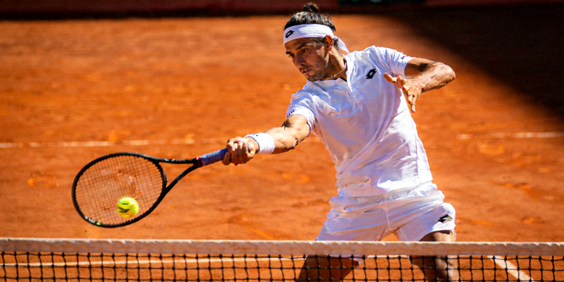 网球运动员在红土场上挥拍击球的专业姿态